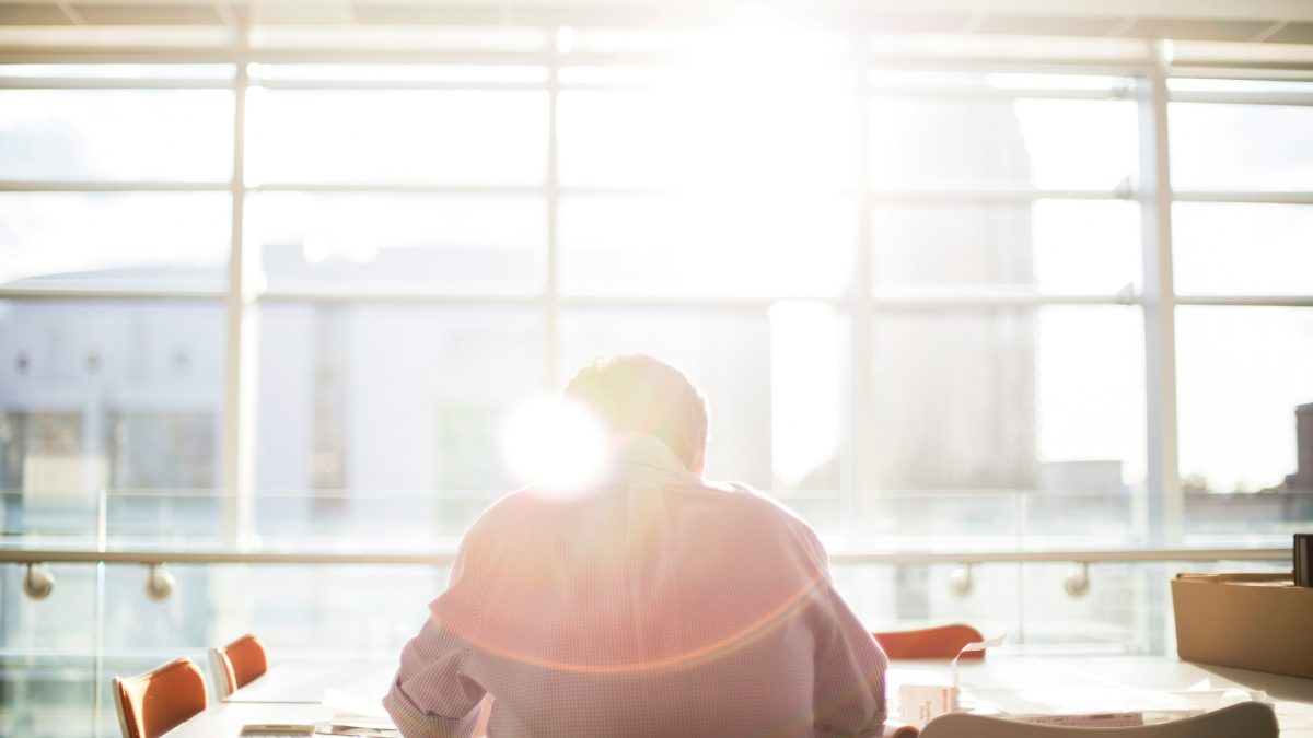 A man sitting on a chair in front of the window during daytime