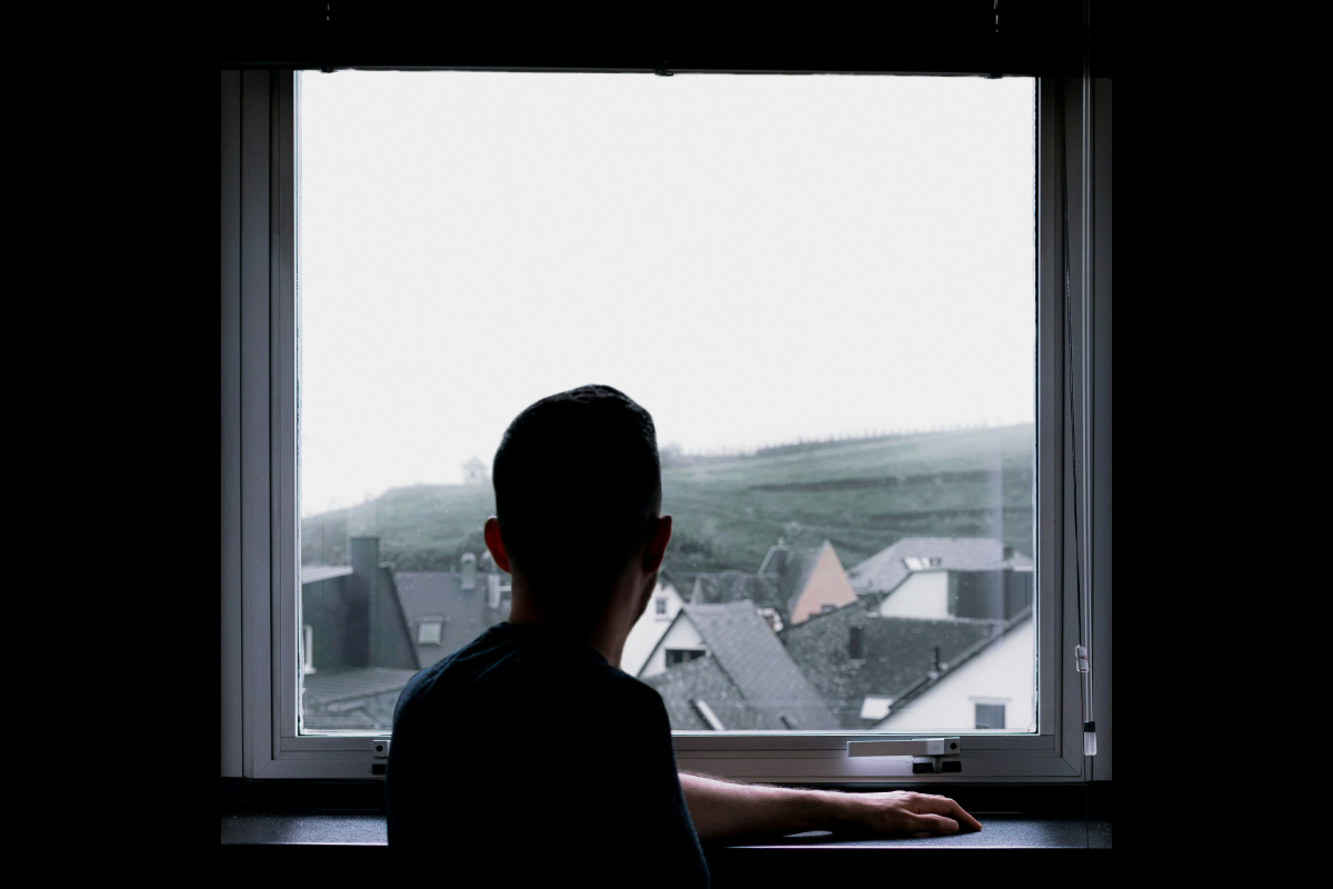 Чоловік біля вікна з віконною ручкою